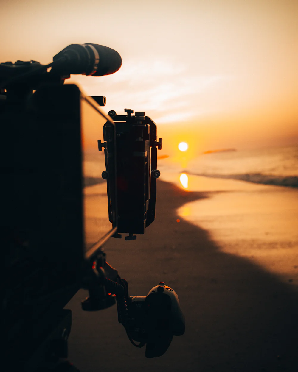 Camera operator filming at sunset