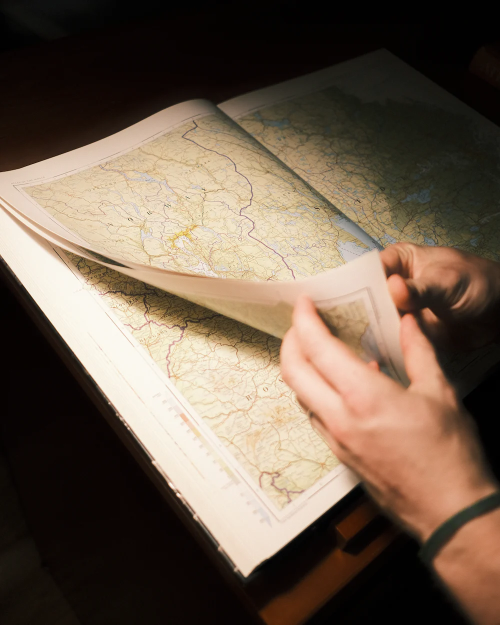 Hands tracing a route across a printed map