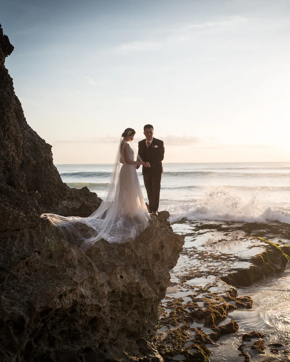 Couple on a cliff above the ocean at a coastal ceremony