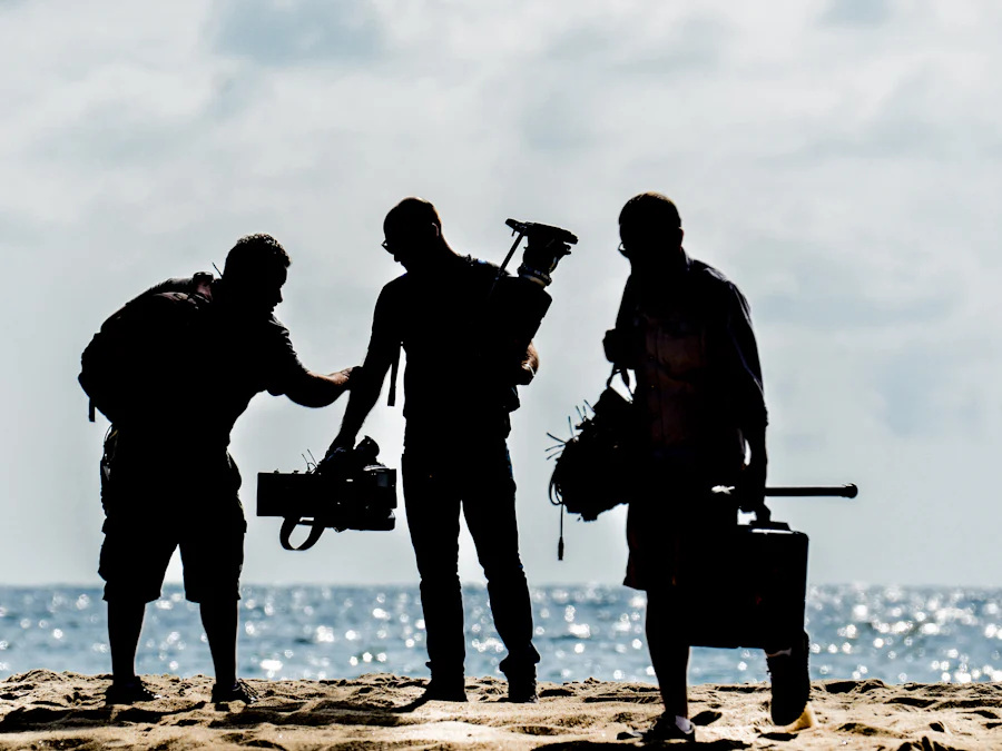 Two crew members with a camera on a beach